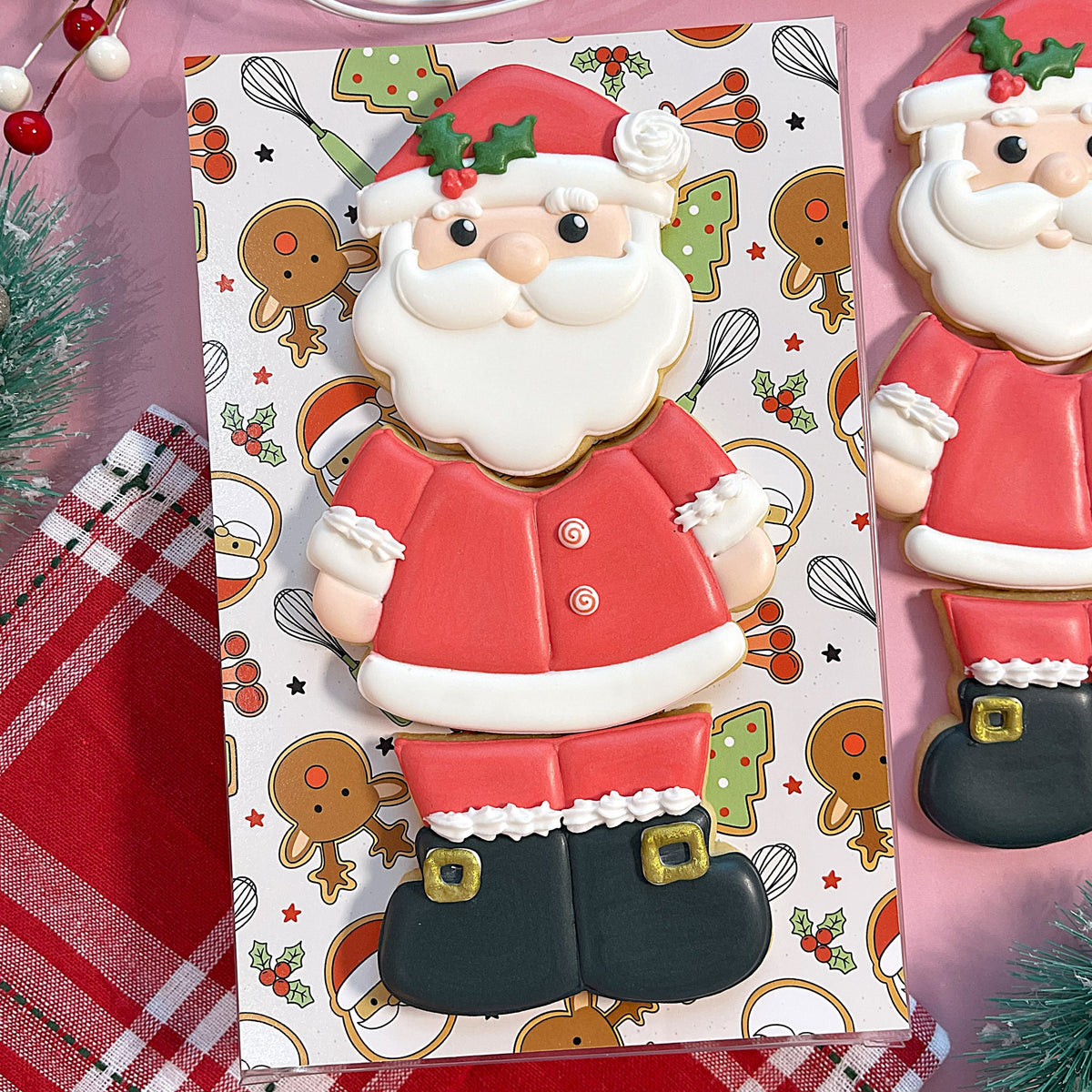 A festive red and white frosted santa claus cookie with gold buckle details made using santa 3-in-1 multi-cookie cutter