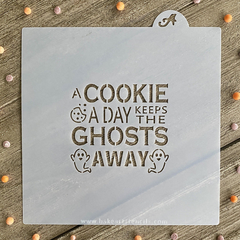 A light gray square baking stencil with a cookie a day keeps the ghosts away phrase and ghost illustrations