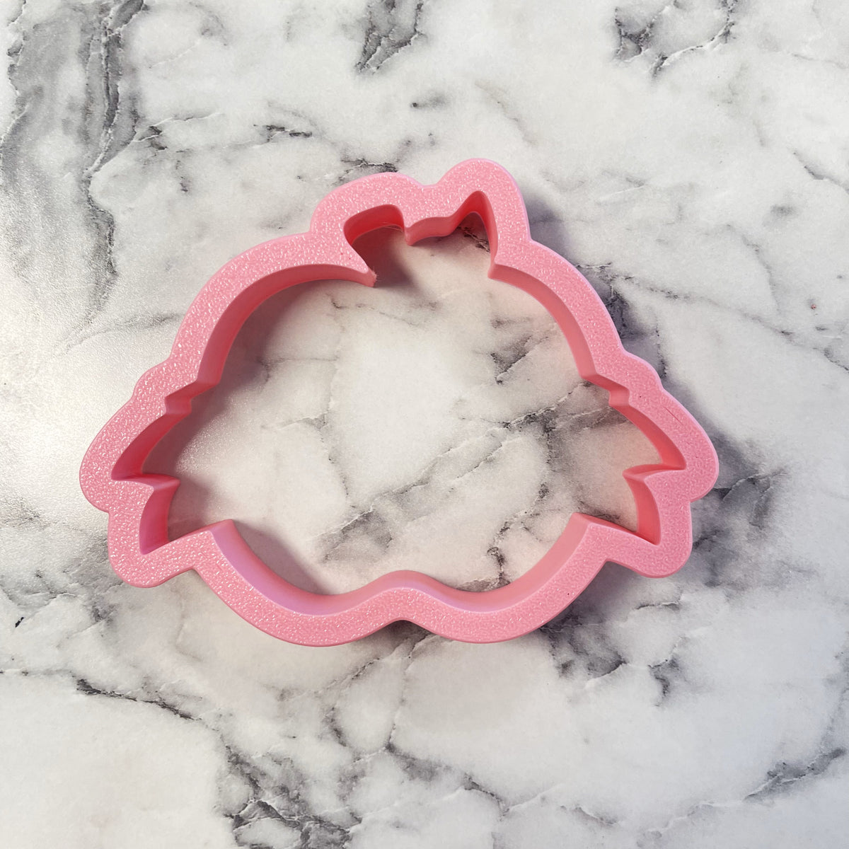 Pink glittery unicorn-shaped apple banner plaque cookie cutter made of durable material for festive baking designs