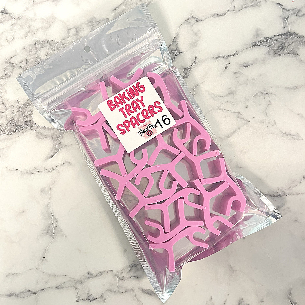 16pc pink silicone baking tray stacking spacers in a clear plastic bag for safe oven use and easy storage