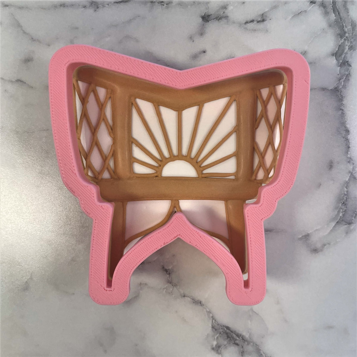 Pink and brown 3d-printed plastic baby bassinet cookie cutter with shopping cart shape and lattice detailing
