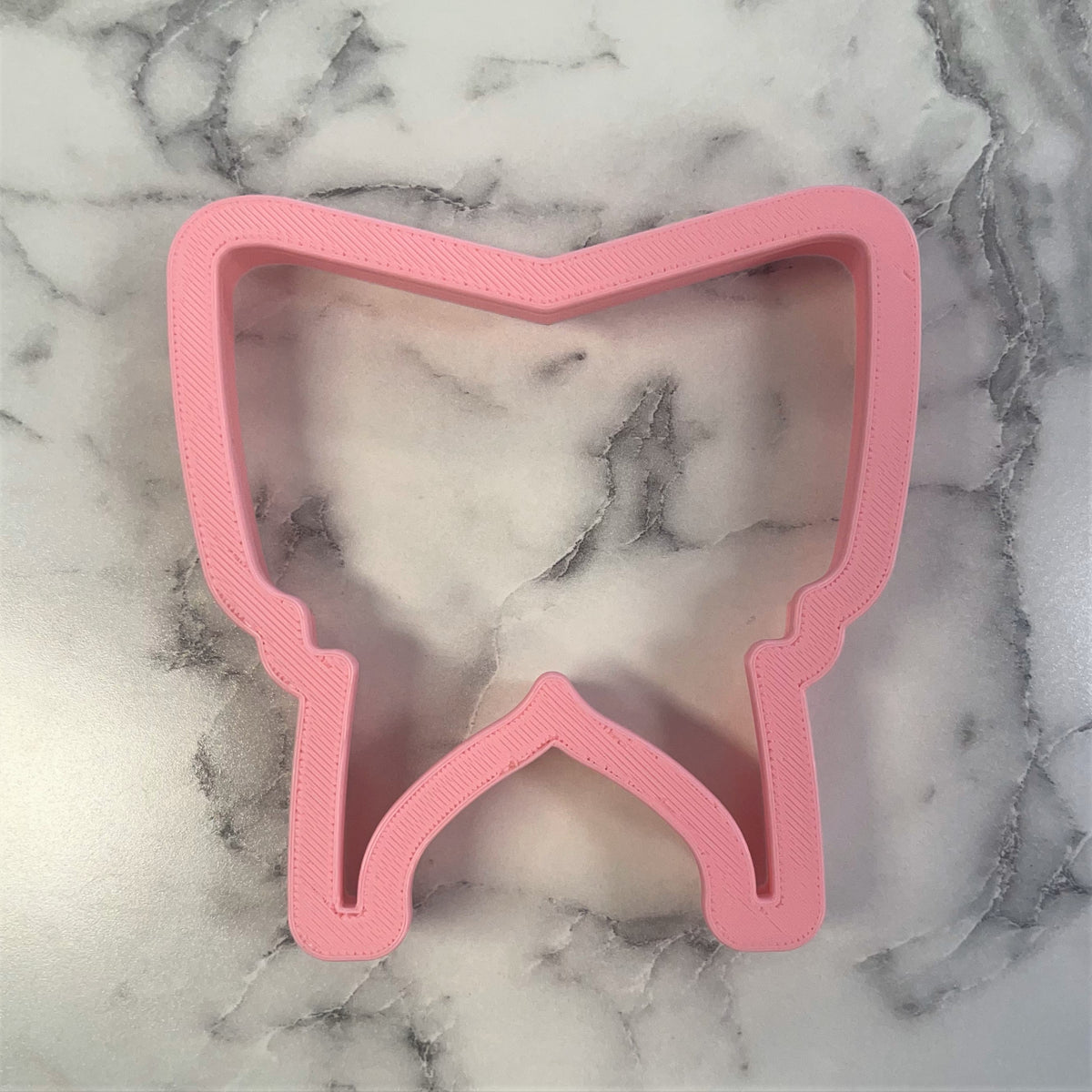 Pink plastic tooth-shaped cookie cutter designed for baby bassinet themed baking and crafting projects