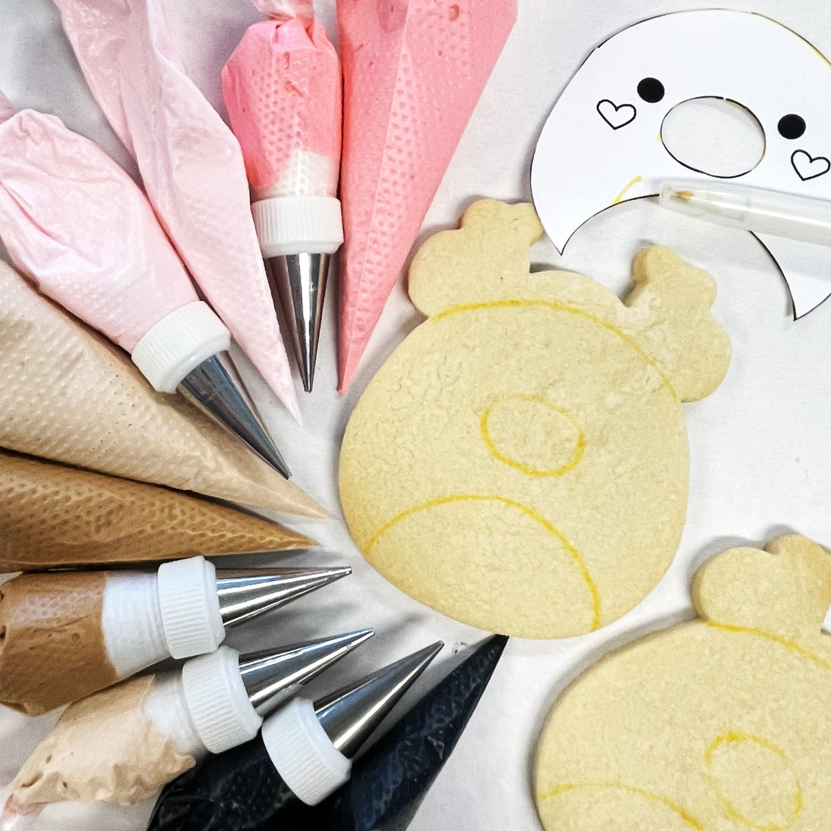 A round light yellow sugar cookie with a simple face drawn in yellow icing made using the squishie bear cookie cutter