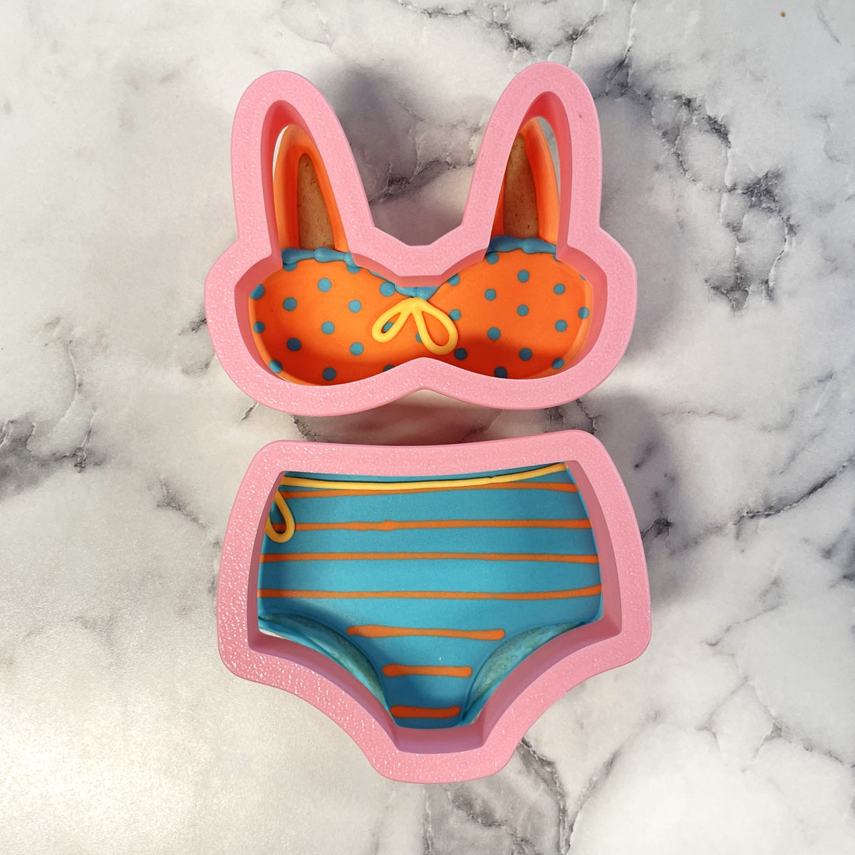 High waist bikini 2pc cookie cutter set in pink silicone shaped like a polka-dot top and striped bottom bikini