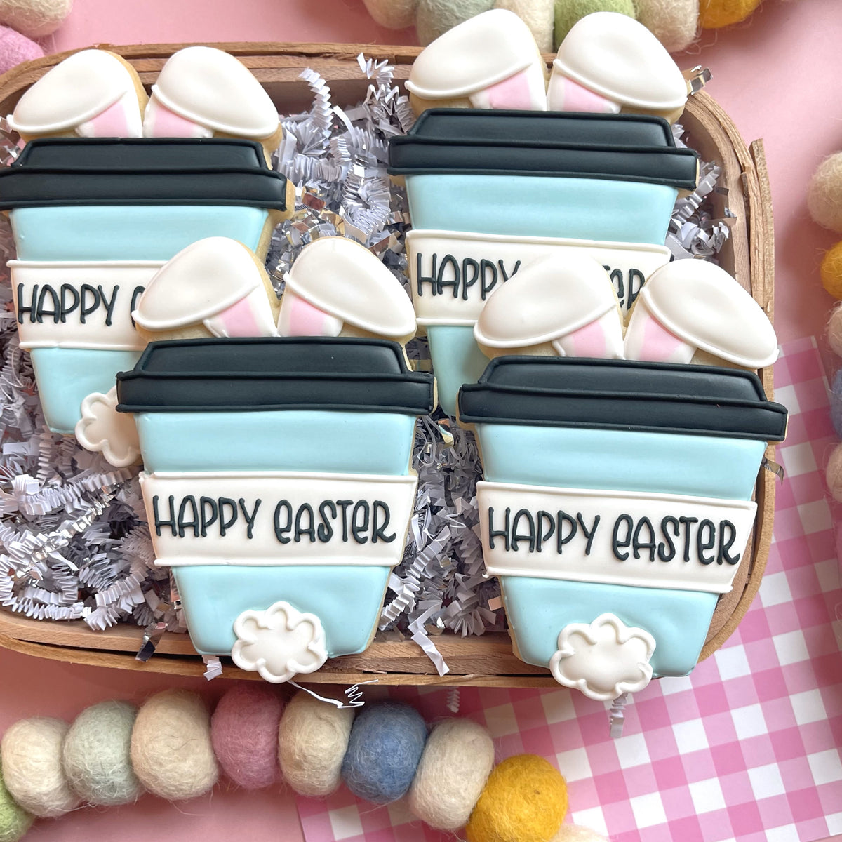 Light blue frosted bunny latte sugar cookies with pink and white bunny ear icing made using bunny latte cookie cutter