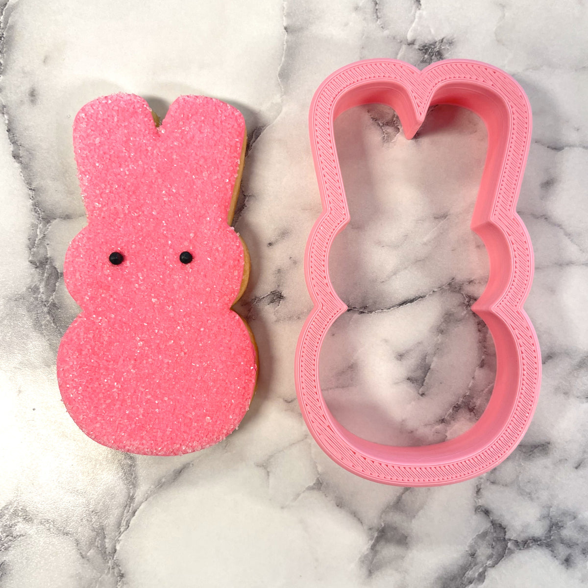 Pink glittery bunny peep flour box cookie cutter with textured raised edge and two small black dot eyes