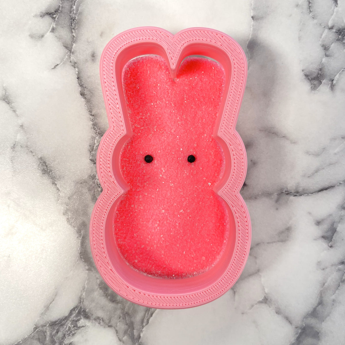 Pink bunny-shaped silicone mold filled with glittery pink sugar for bunny peep flour box cookie cutter