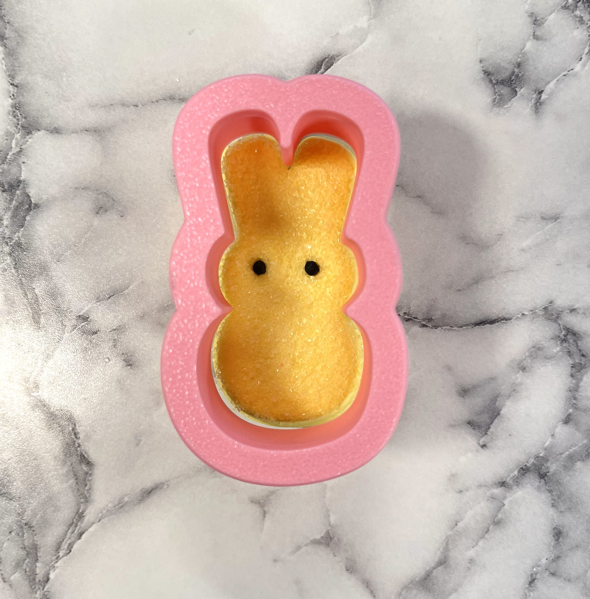 Mini bunny peep flour box cookie cutter pink silicone mold holding a yellow glittery peep marshmallow bunny