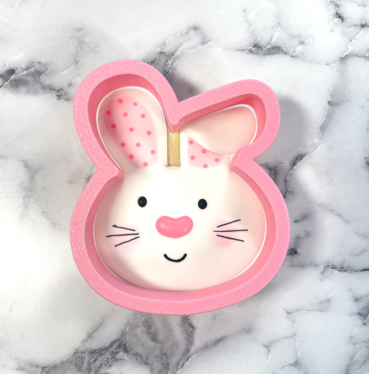 Pink bunny with floppy ear cookie cutter featuring polka-dotted ears and a smiling face for baking fun