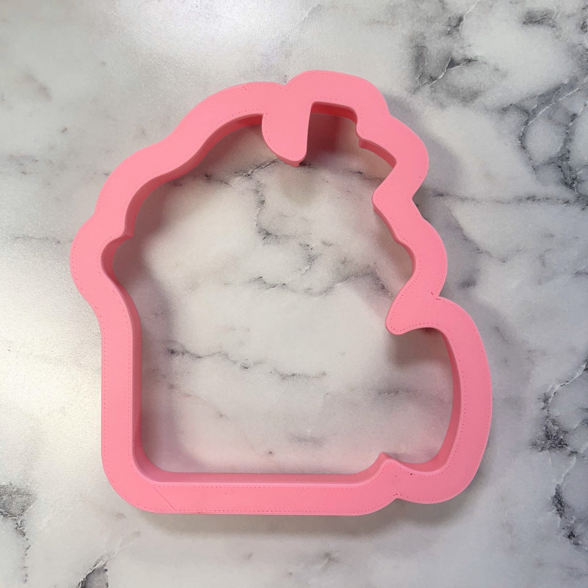 Pink silicone campfire mug cookie cutter shaped like a cupcake for baking and crafting use