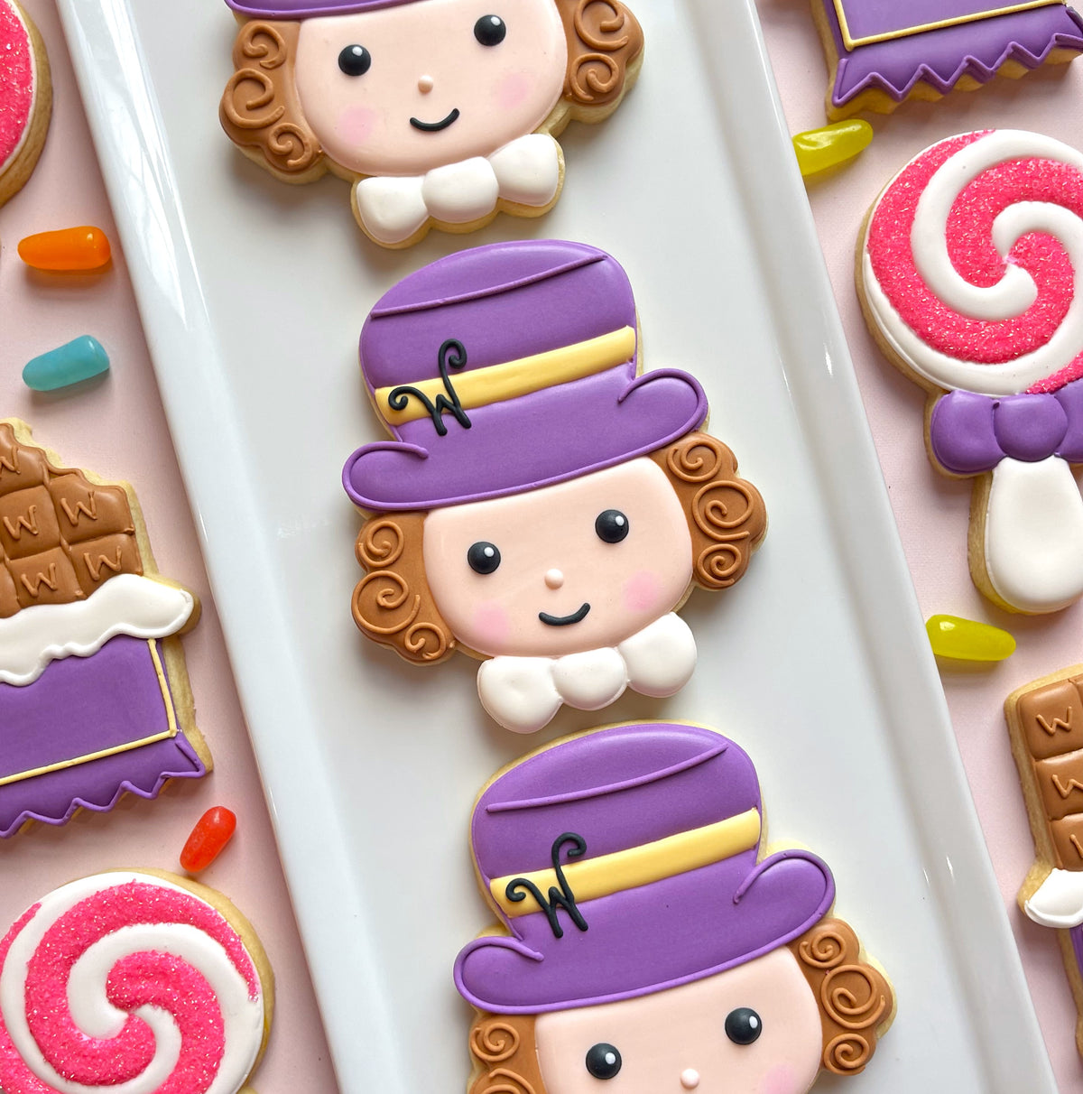Purple-hatted curly-haired cookie cutouts with white bows and black eyes from the candymaker cutter bundle