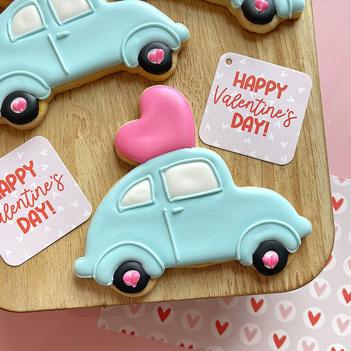 Pastel blue car-shaped cookie with black wheels and pink heart details from valentine 2025 cookie cutter set