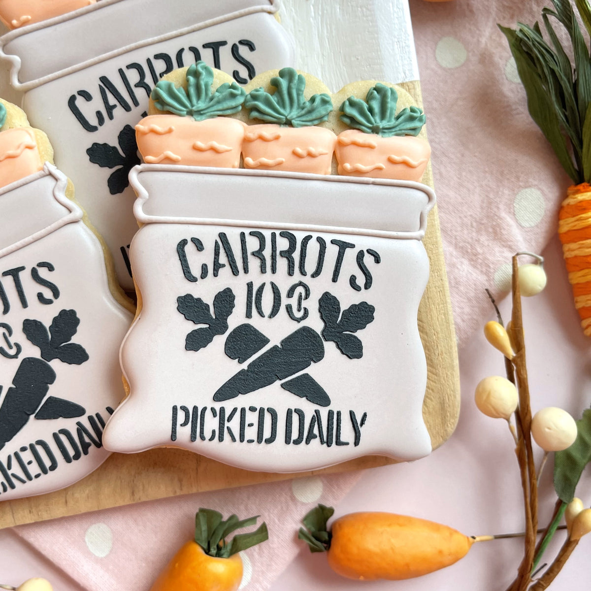 White frosted carrot crate cookie with black text carrots 103 picked daily and green leaf accents from bunny farmer cookie cutter bundle with stencil