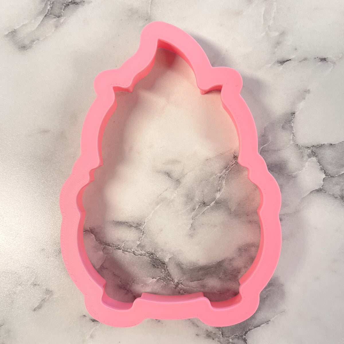 Pink silicone cauldron cookie cutter mold shaped like a gnome for baking and crafting use