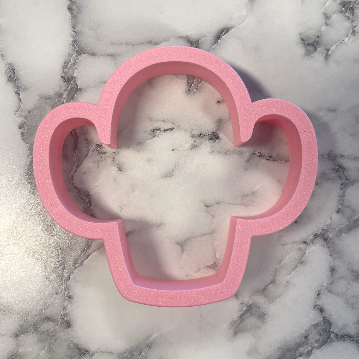 Pink glittery cloud-shaped chubby cactus cookie cutter made of durable plastic for fun baking projects