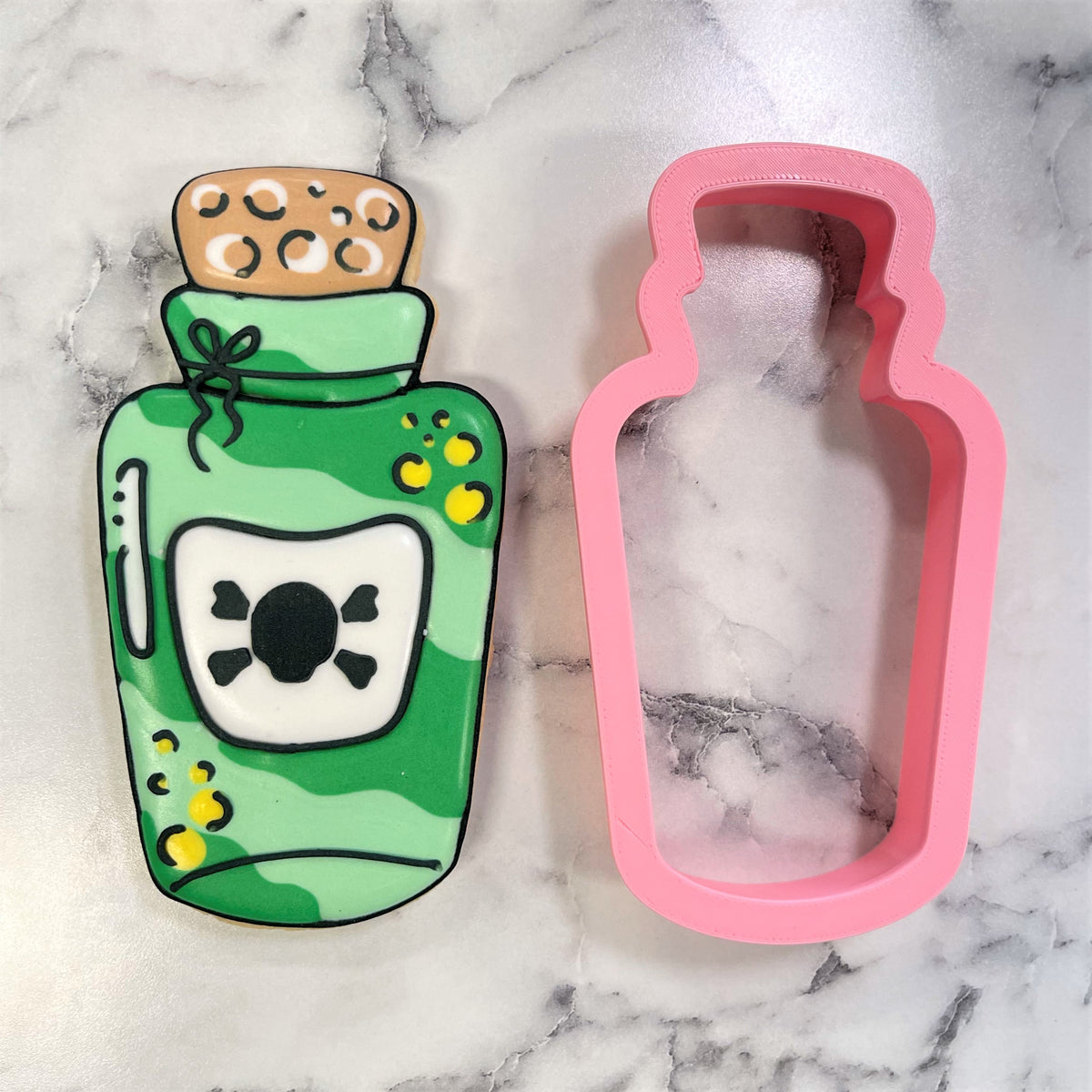 Comic potion bottle cookie cutter in green camouflage with brown cork and black skull label for themed baking