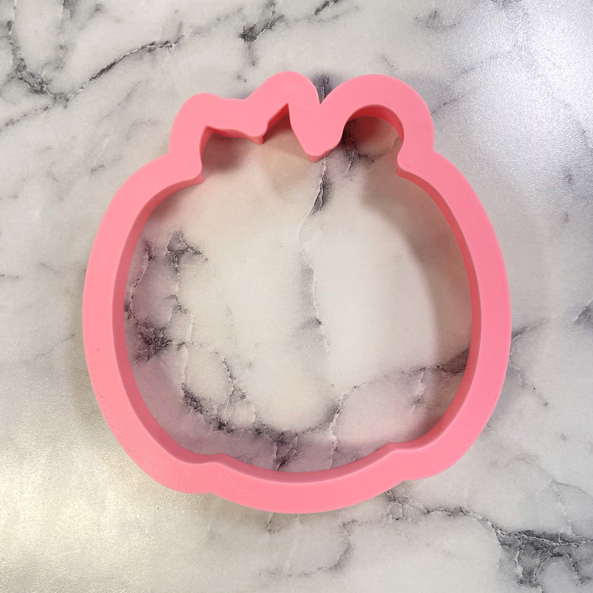 Pink silicone comic jack-o-lantern cookie cutter shaped like a pumpkin for Halloween baking and crafts