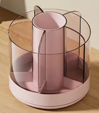 Pink cylindrical cookie decorating tool spinning caddy with clear acrylic dividers and rotating base for organization