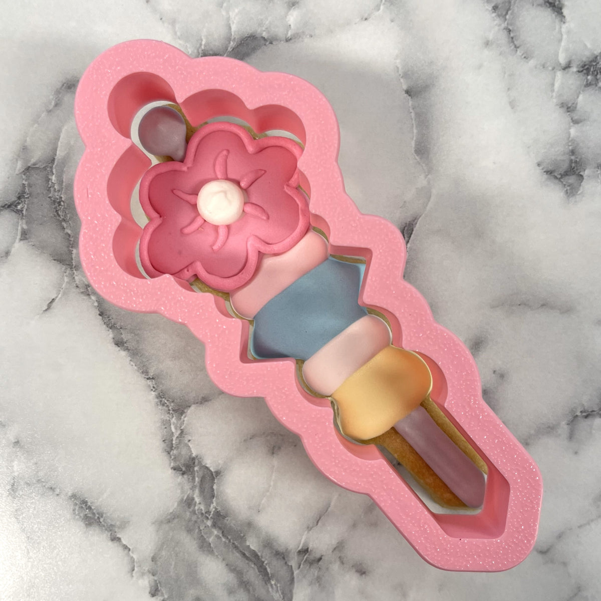 Pink glitter silicone ice cream cone mold with pink flower design and pastel sections for cookie scribe cookie cutter