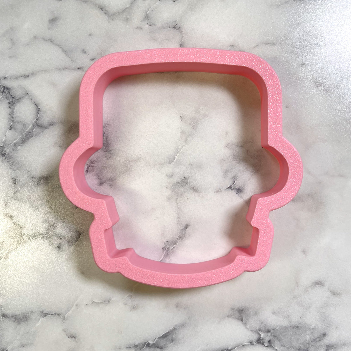 Pink silicone cookie cutter shaped like a cute chubby cartoon skull for fun baking and decorating