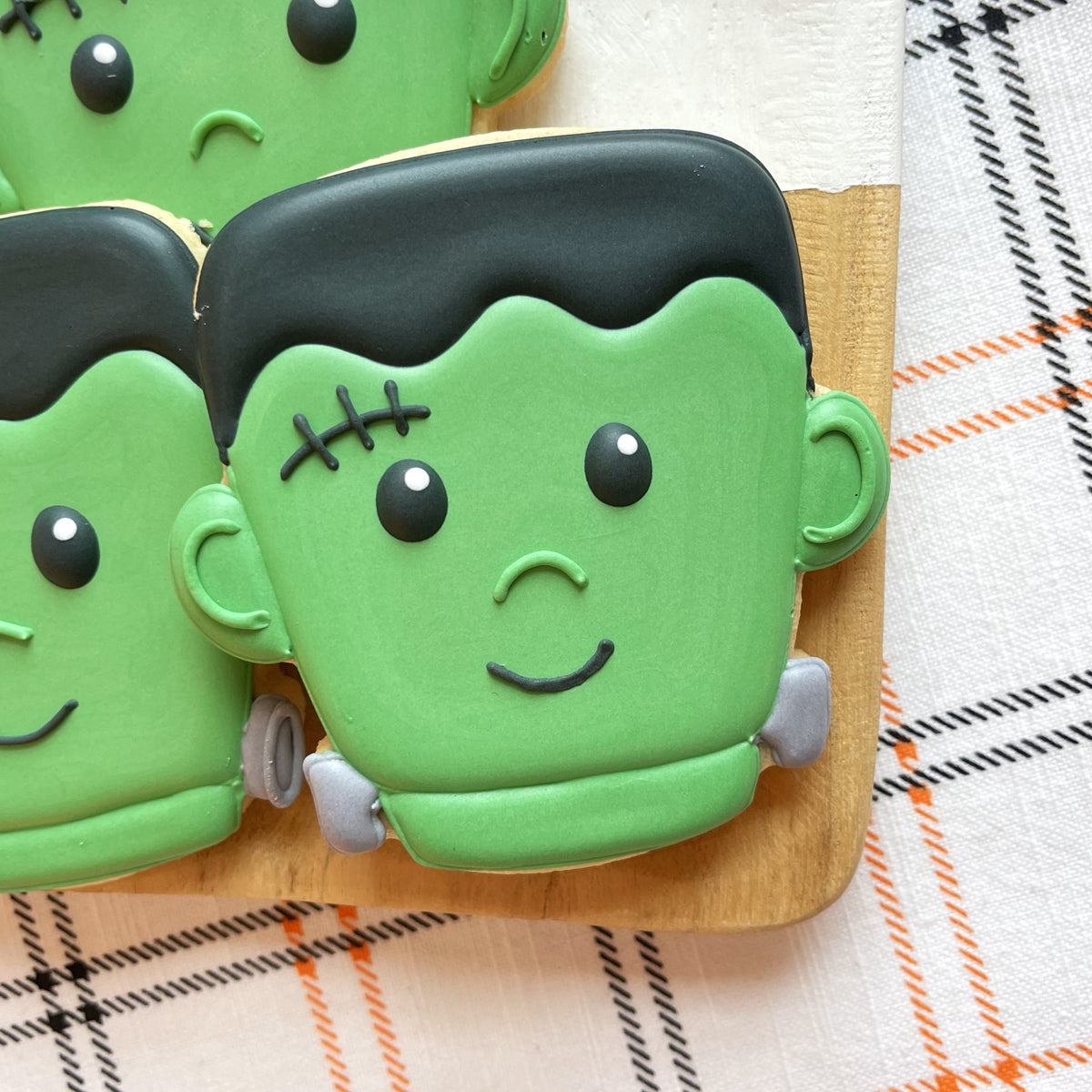 Cute chubby halloween cookie cutter bundle featuring a green frosted frankenstein cookie with black icing hair and stitched eyes