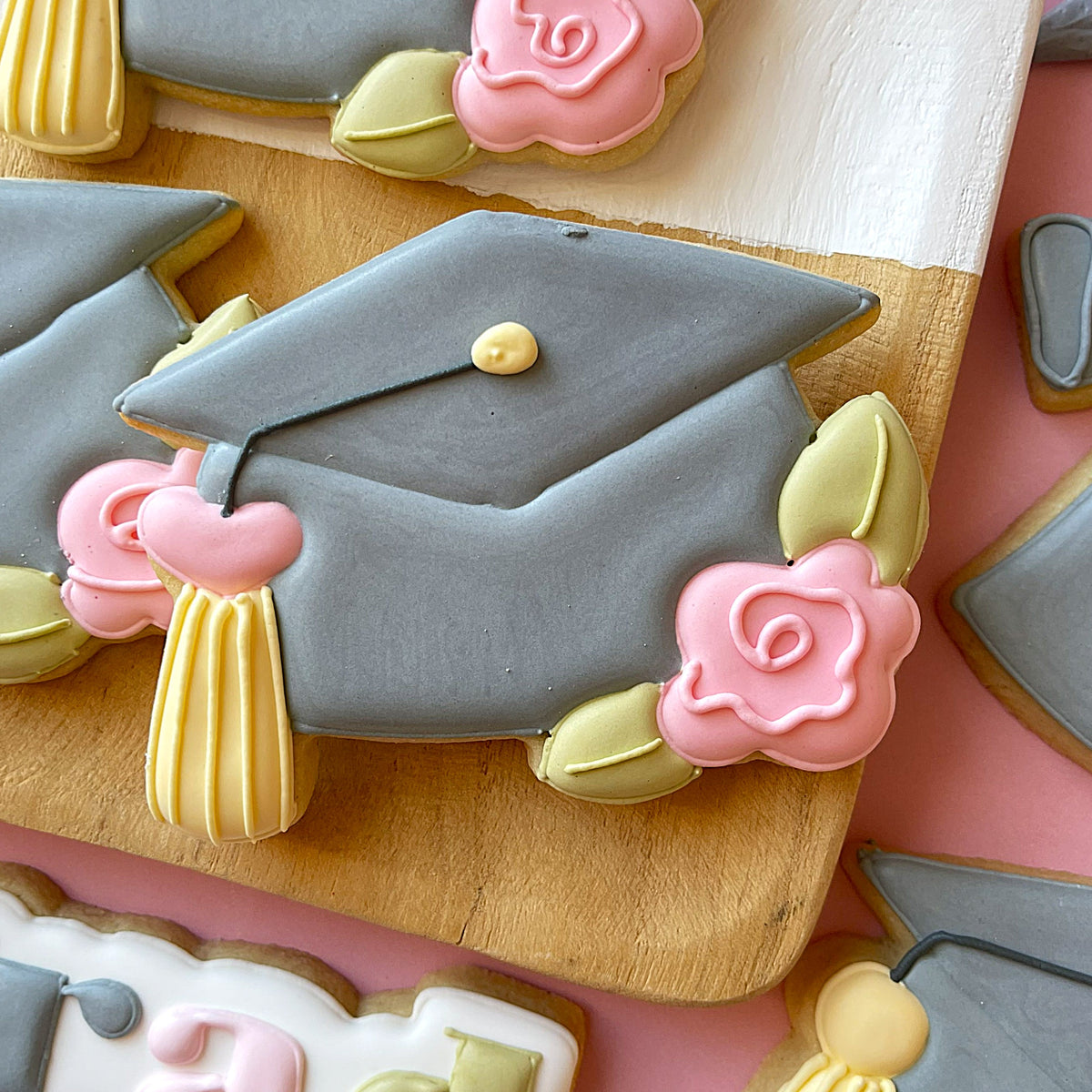 Gray graduation cap cookie decorated with pink roses and yellow tassel from 2026 grad cutter release set