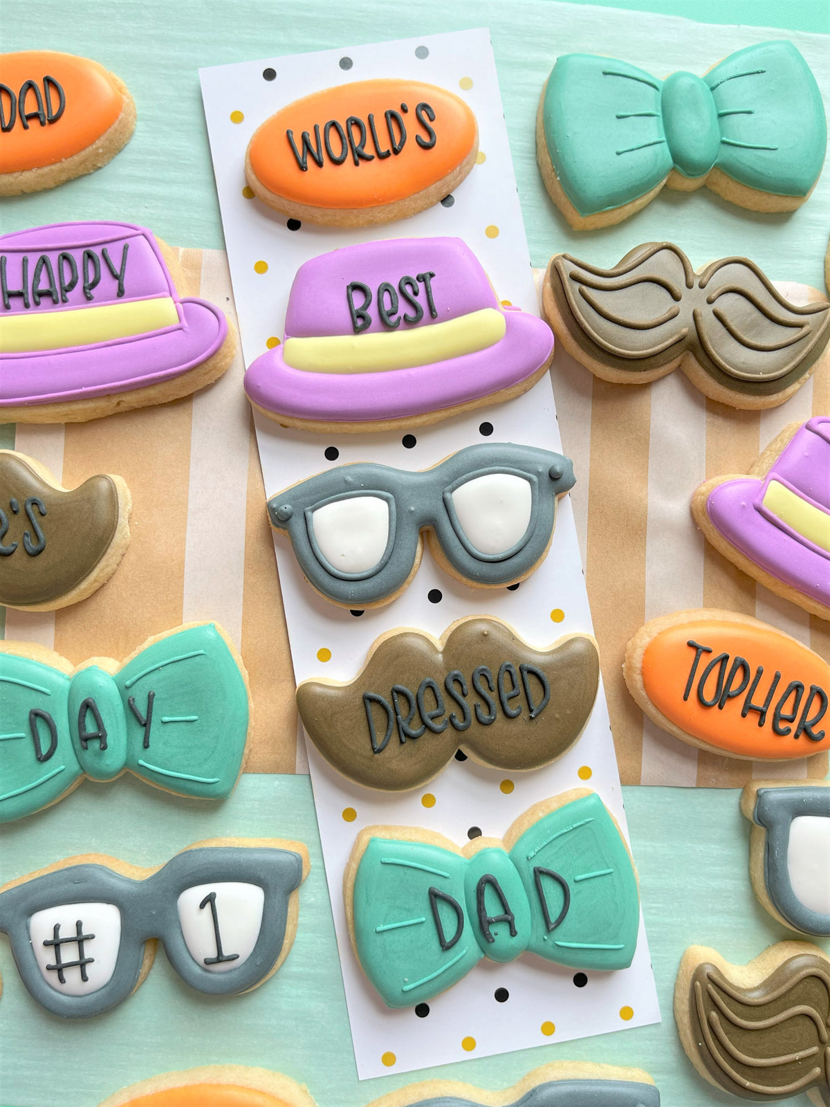 Pastel-colored sugar cookies shaped like bow ties hats mustaches and glasses made with mini hat cookie cutter and edible icing details