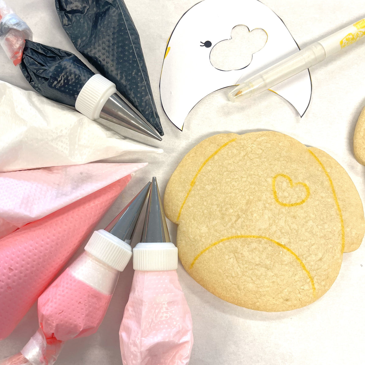 A golden-brown sugar cookie shaped like a sad face with yellow icing made using a squishie dog cookie cutter
