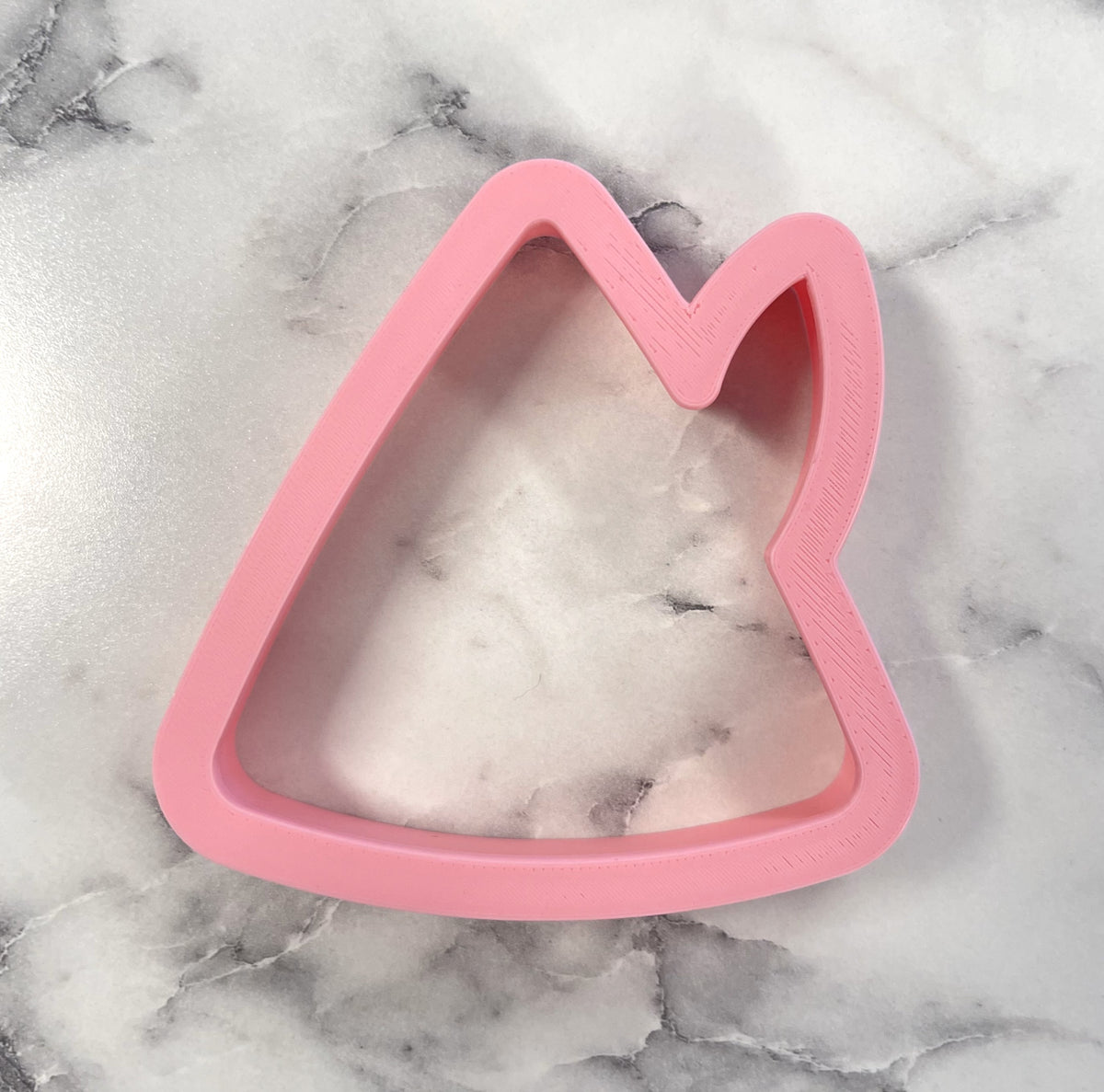 Pink silicone elf hat cookie cutter with cat ear design for baking and decorating festive cookies