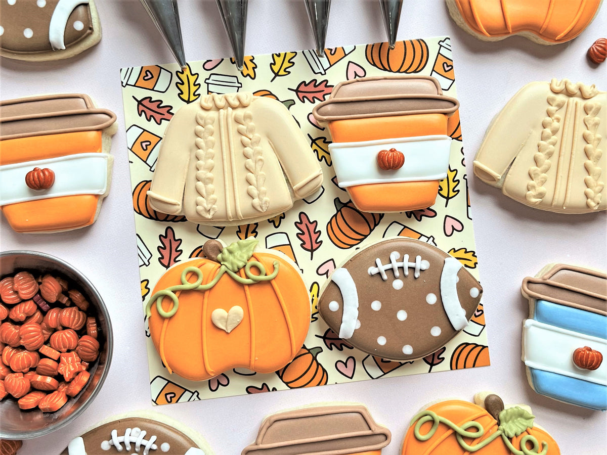 A vibrant orange pumpkin-shaped cookie with a green stem and white heart from mini fall 4pc flour box club cutter set