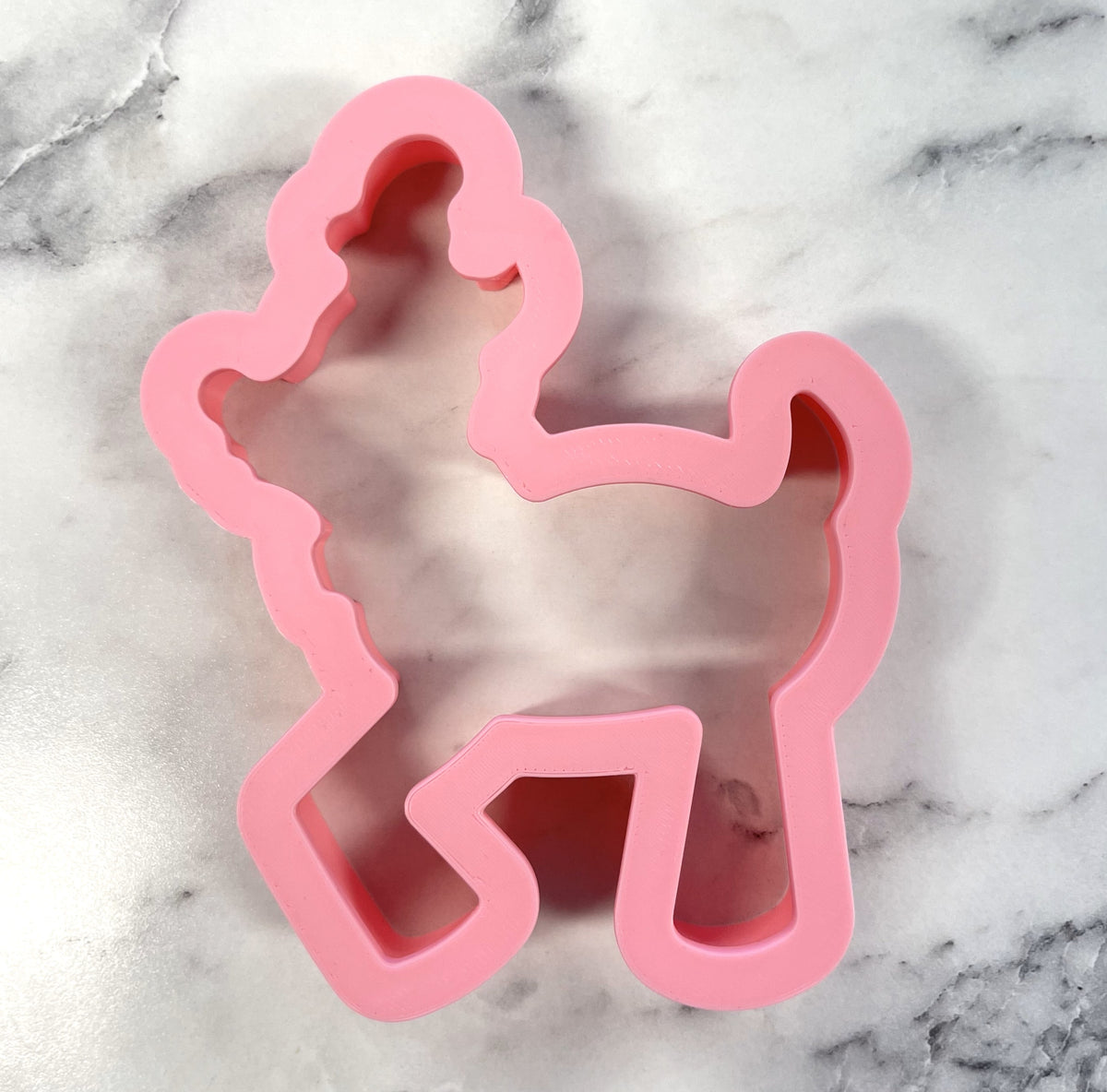 Pink silicone cookie cutter shaped like a poodle for festive baking from the flying reindeer cookie cutter collection