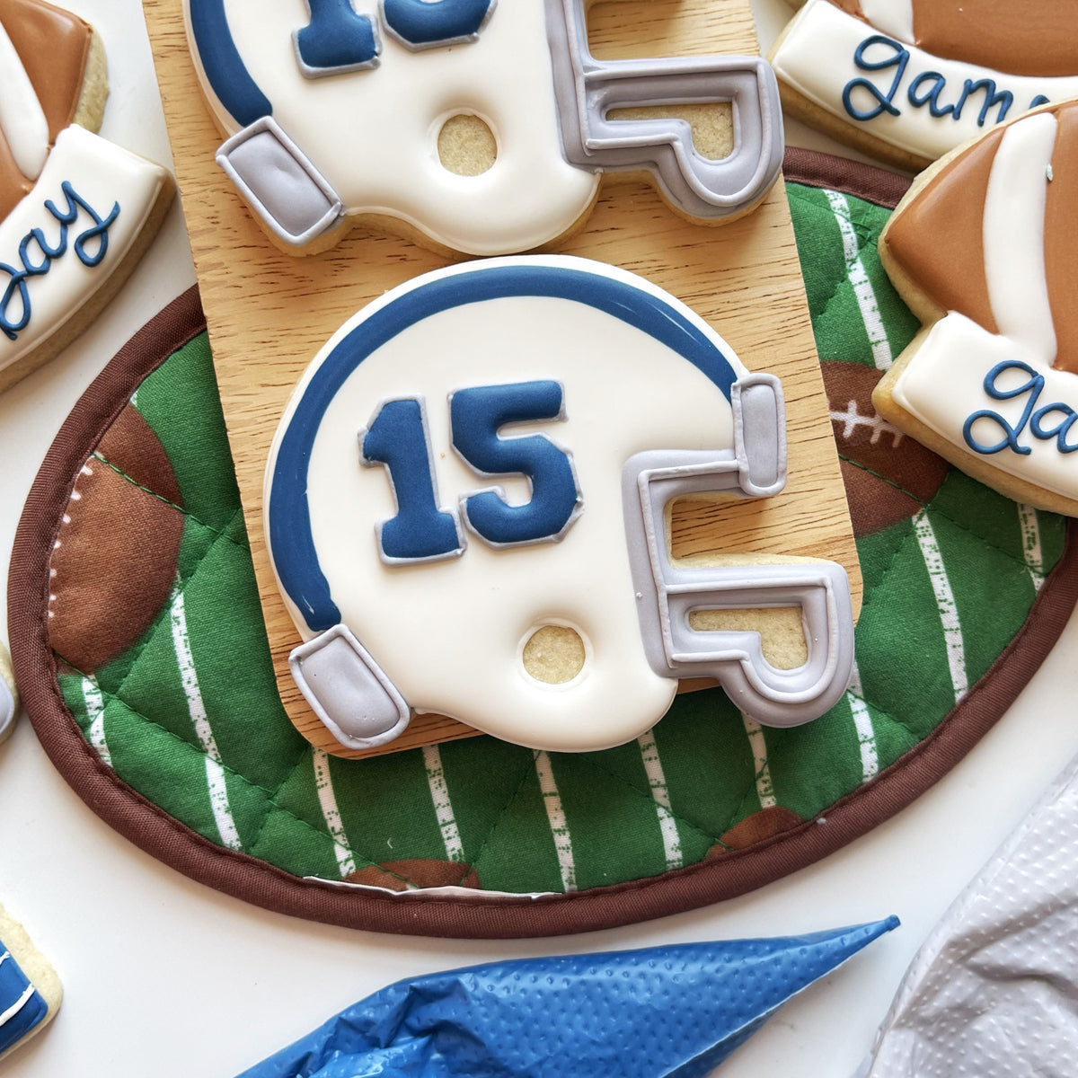 White and blue football helmet-shaped cookie decorated with number 15 icing from football cookie cutter bundle