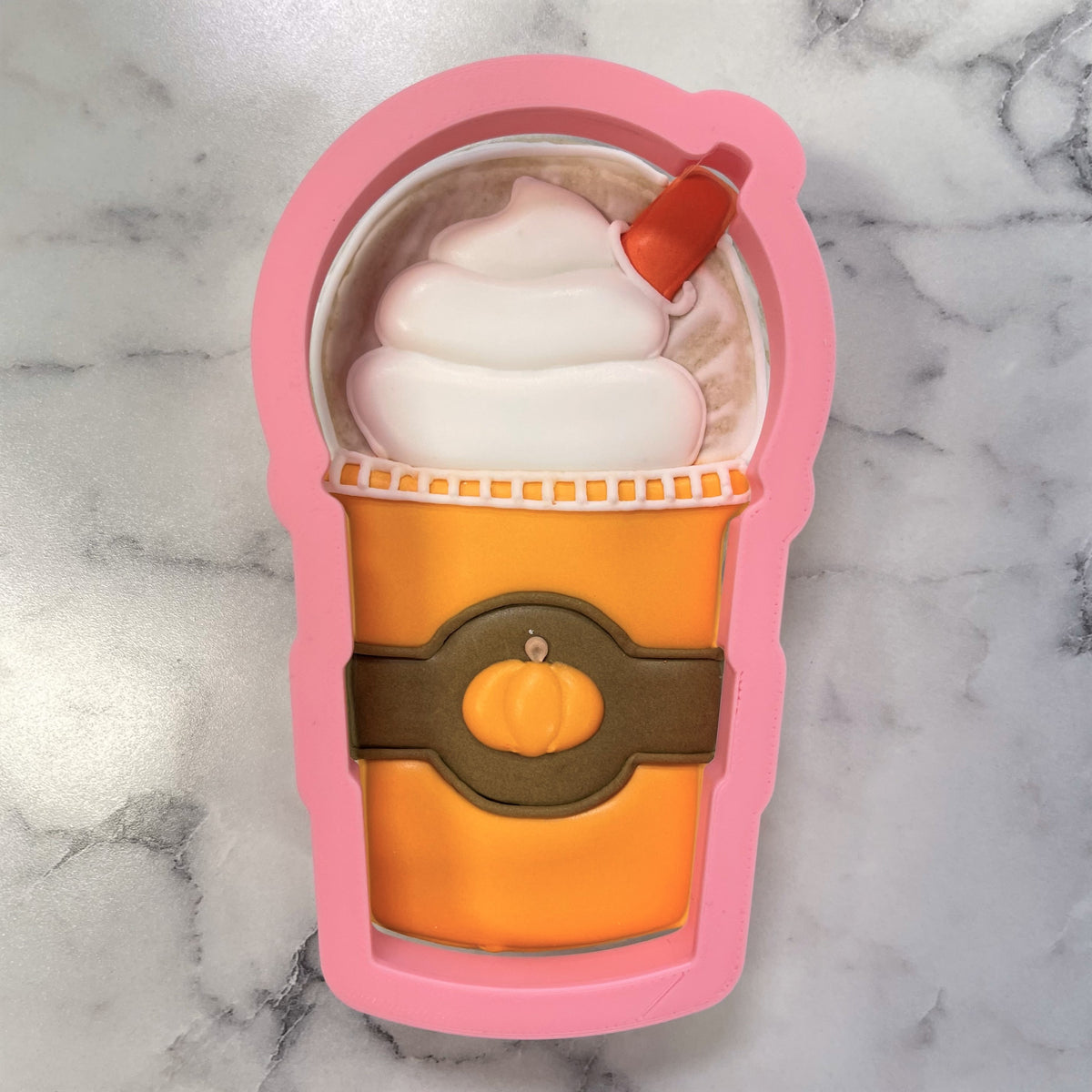 Pink silicone frappuccino cookie cutter shaped like a pumpkin spice latte with orange cup white whipped cream and red straw