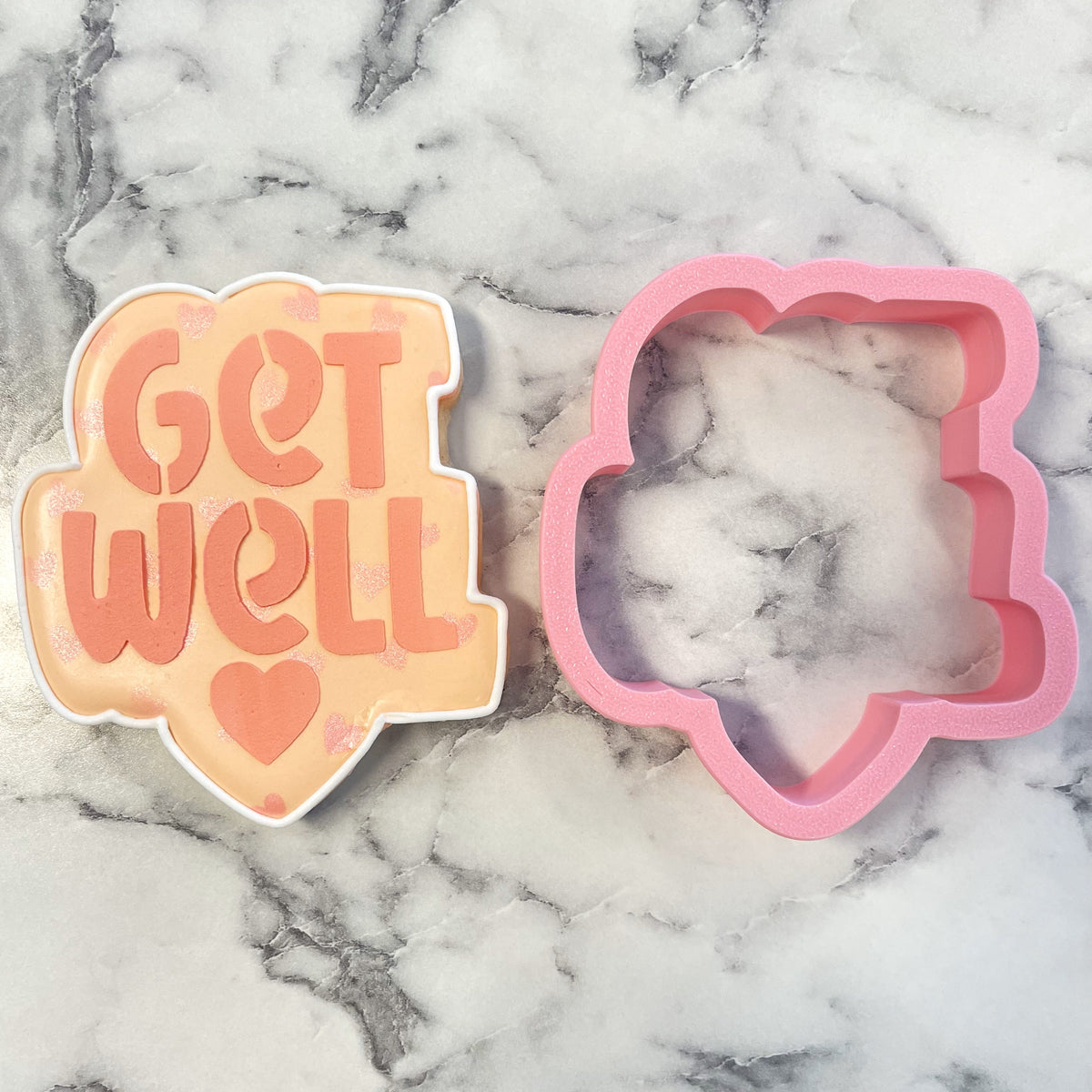 Pink silicone get well cookie cutter and stencil set shaped like a cloud with orange get well and heart design
