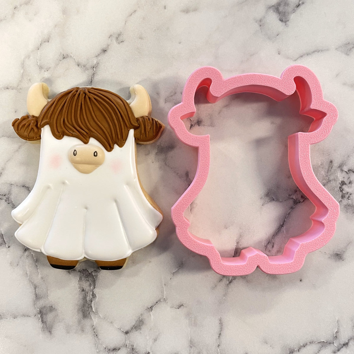 Pink silicone cookie cutter shaped like a highland cow with horns and brown hair for western ghost highlander cow cookies
