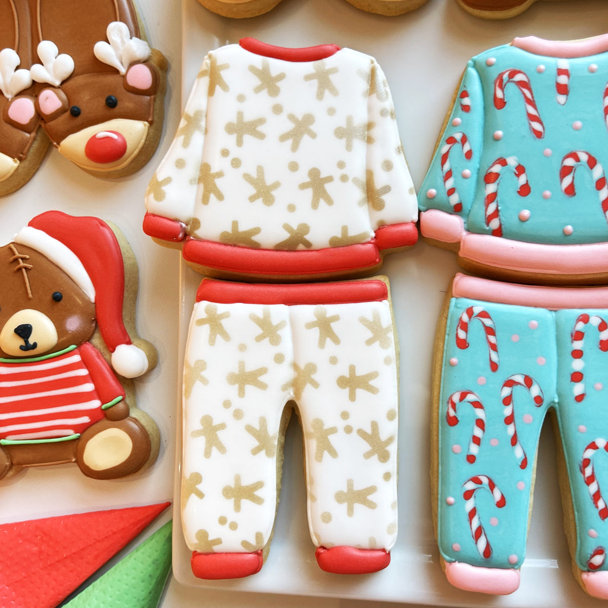 White sugar cookie pajamas two piece set with gold gingerbread man patterns and red trim for cozy wear