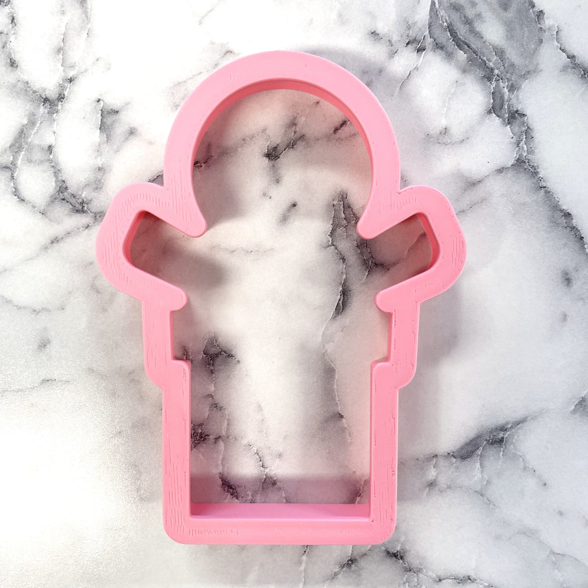 Pink plastic cookie cutter shaped like a fire hydrant from the gingerbread in present cookie cutter set