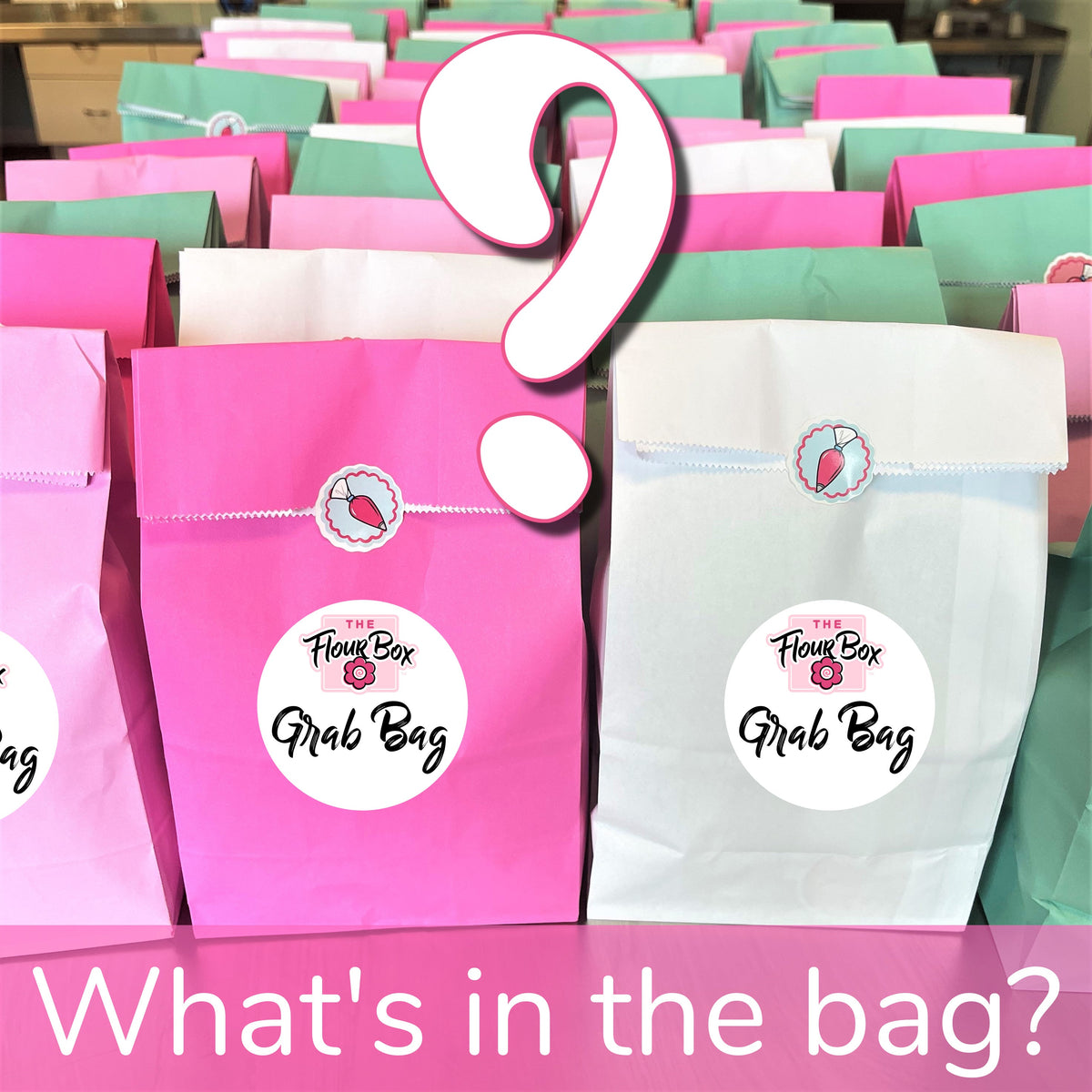 Pink paper grab bag with white flap and the flour box logo containing metal cookie cutters for baking use