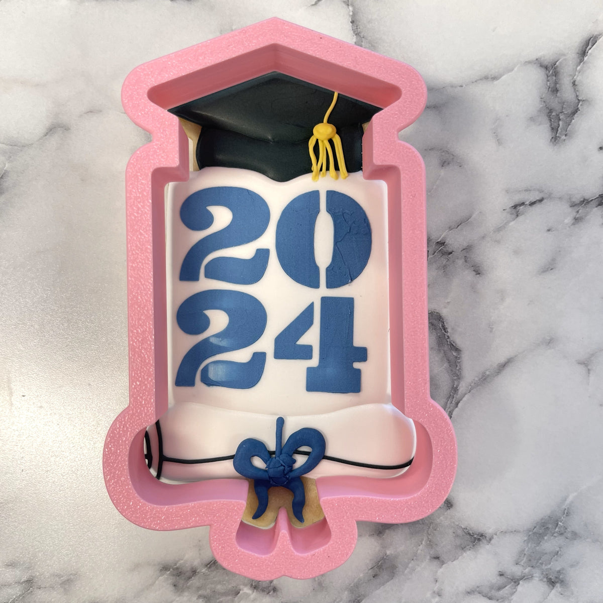 Pink silicone grad cap yearly plaque cookie cutter with black cap yellow tassel and blue 2024 fondant decoration