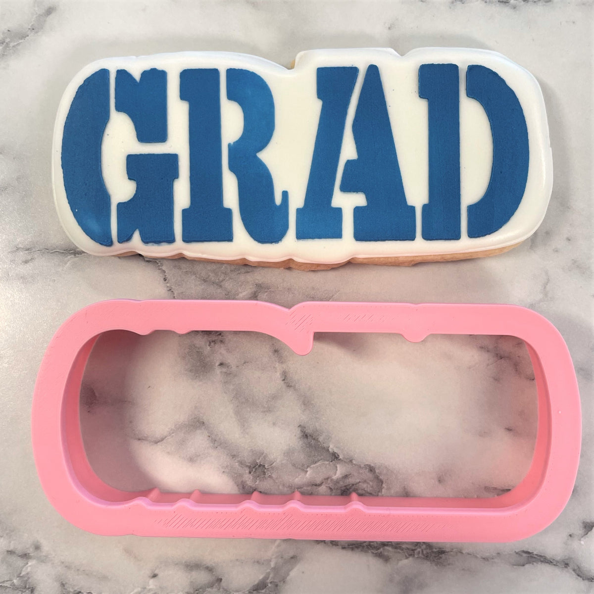 Blue and white grad cookie cutout with pink silicone baking mold from grad plaque flour box club cookie cutter with stencil