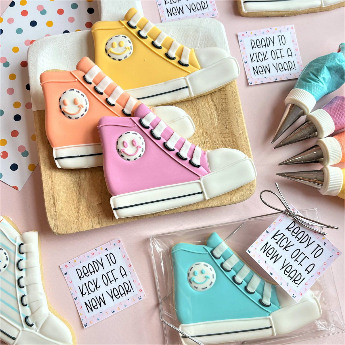 Pastel-colored high top sneaker-shaped cookies with smiley face decorations and white laces made using a cookie cutter