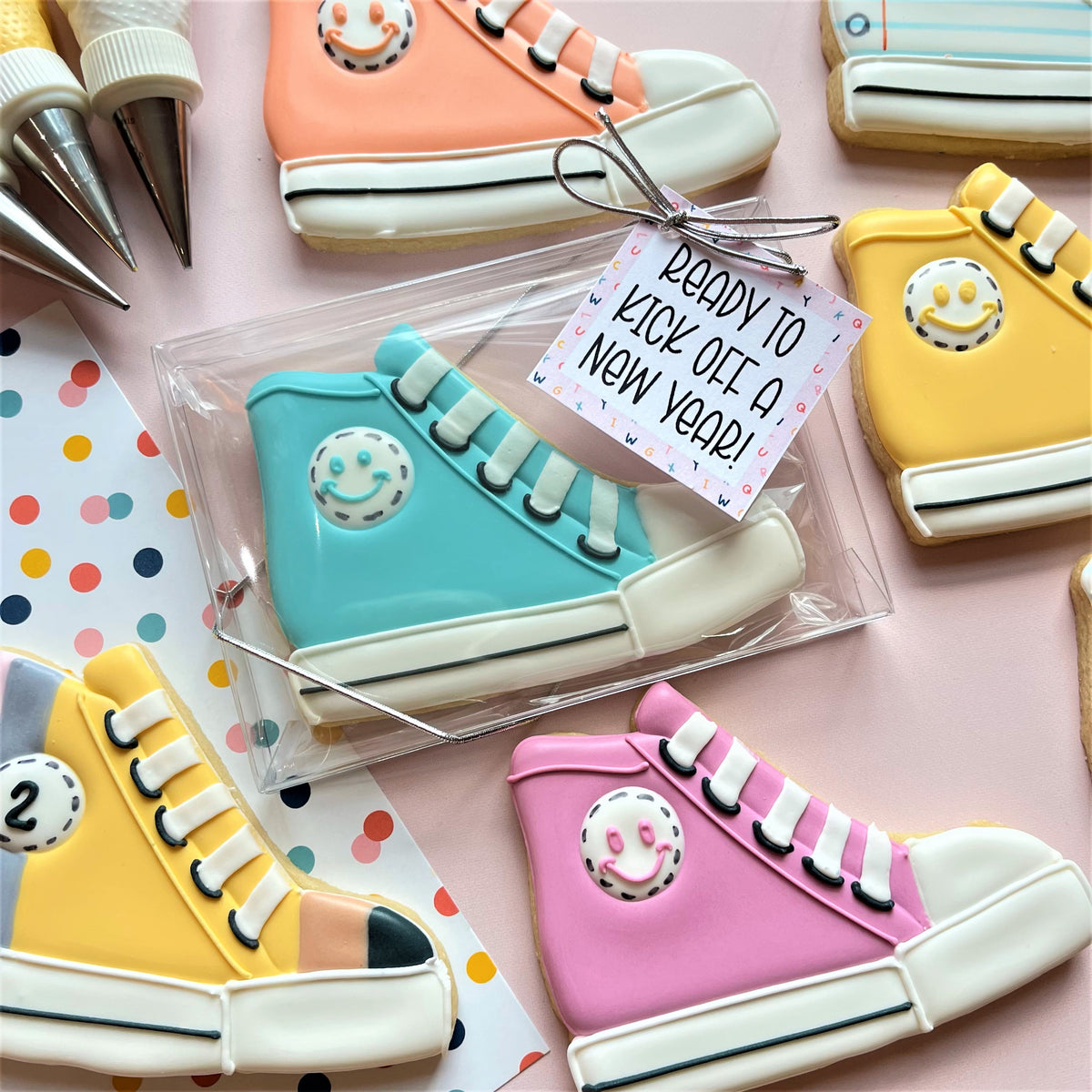 Turquoise high top sneaker cookie shaped with white laces black eyelets and smiling face design for baking