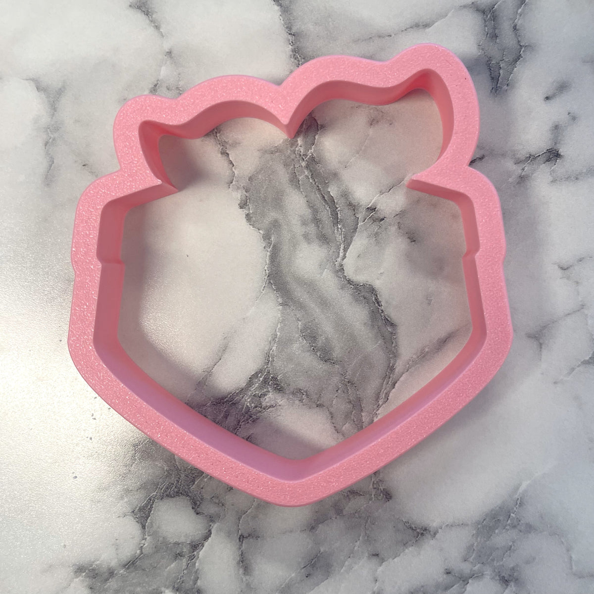 Pink glittery silicone handkerchief cookie cutter shaped like a bear’s head for baking and decorating