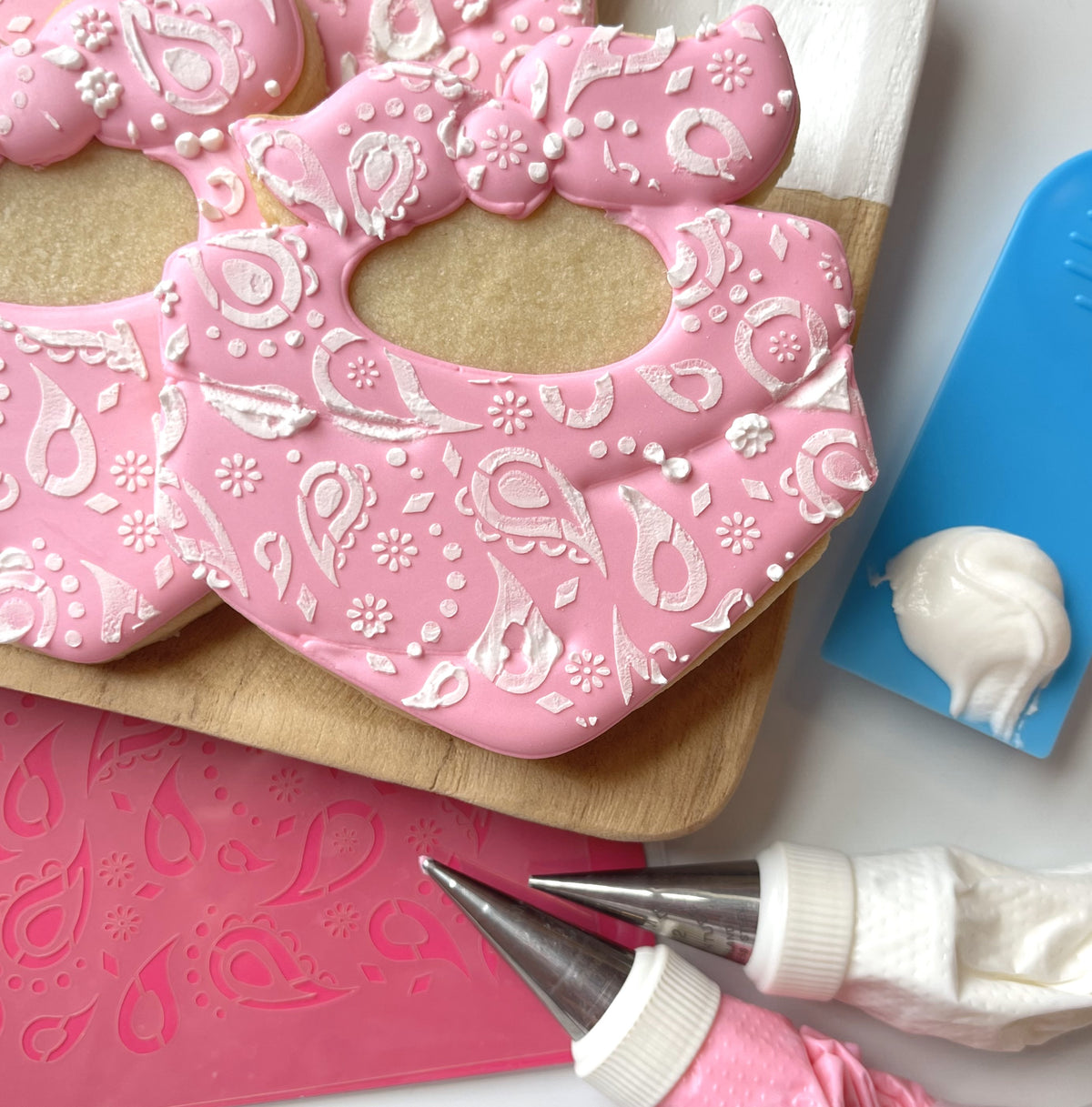Pink bandana-patterned sugar cookie with white icing details featured in western decorating online class recording