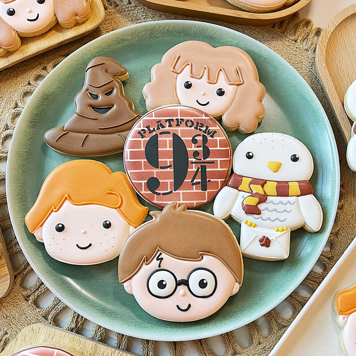 Delicate harry potter-themed sugar cookies with pastel icing featuring hermione ron sorting hat and platform 9 3/4 stencil