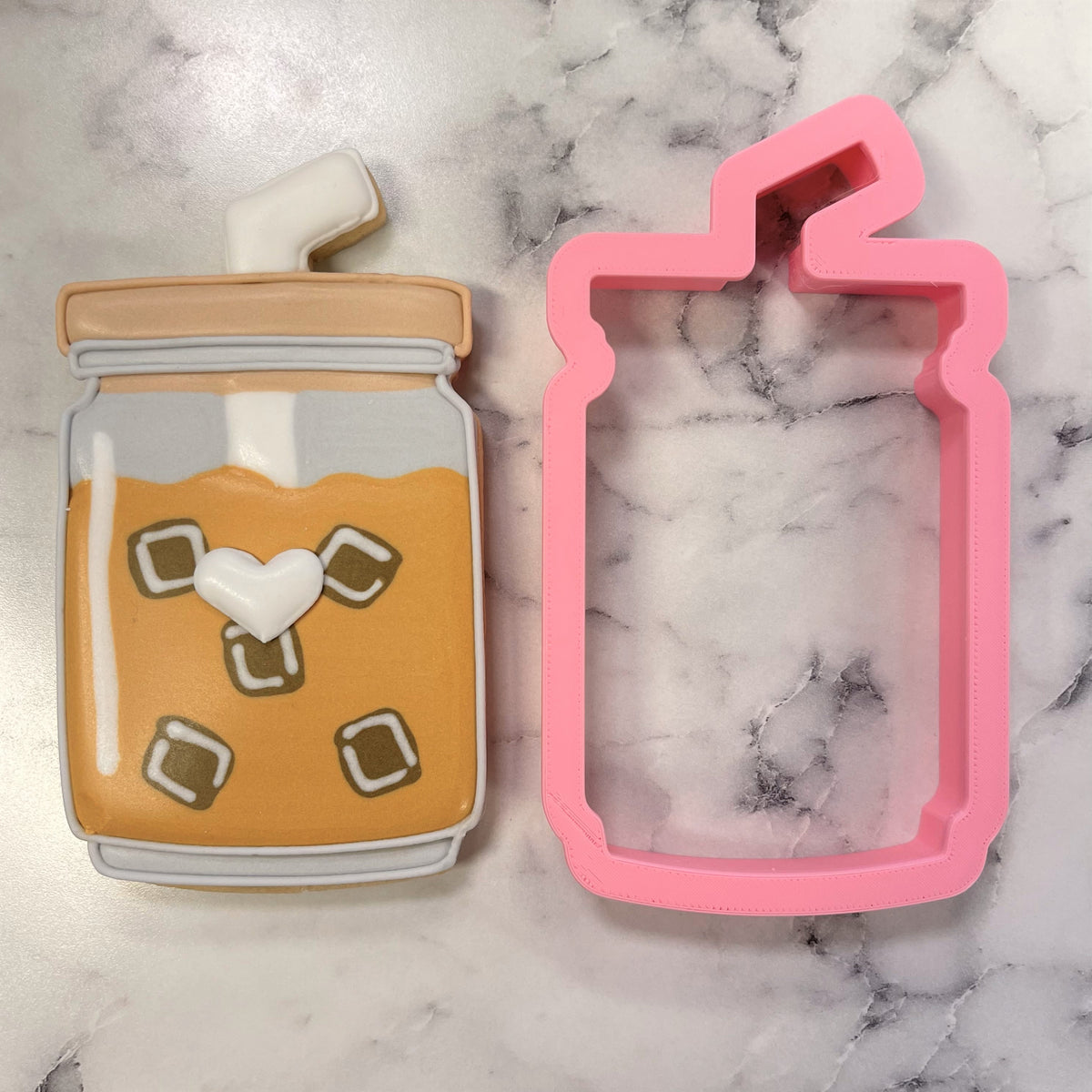 Pink plastic iced coffee cup cookie cutter shaped like a drink jar with a straw for baking and crafting