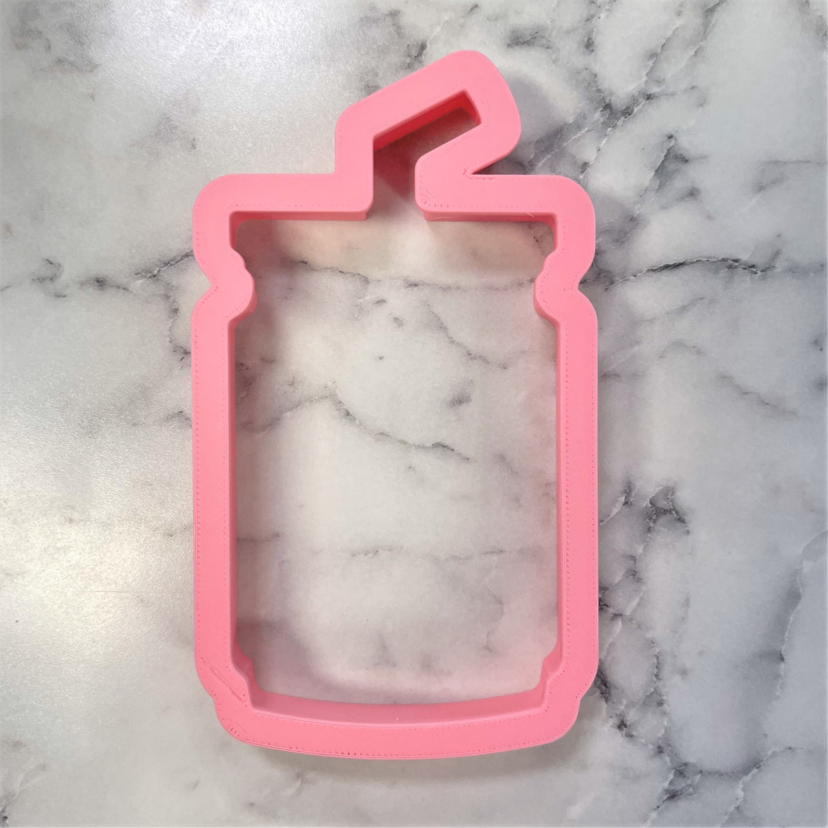 Pink silicone iced coffee cup cookie cutter shaped like a drink with a straw for baking and crafting