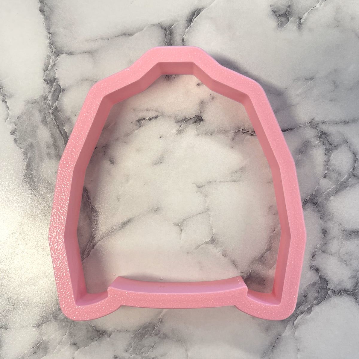 Pink glittery silicone jean jacket cookie cutter shaped like a hooded sweatshirt for baking and crafting