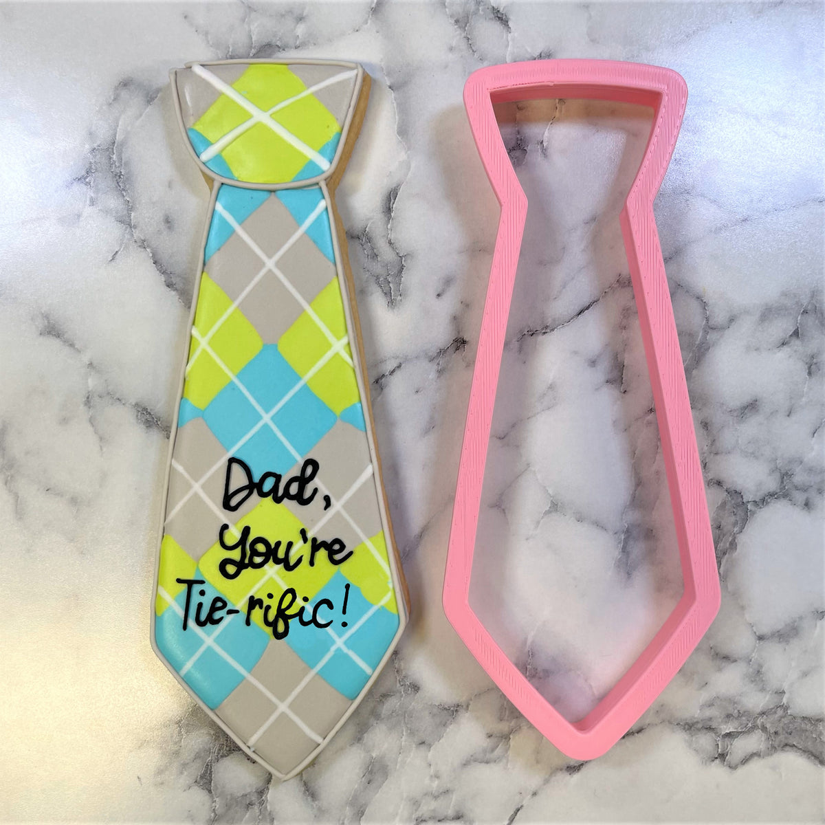 Jumbotron tie cookie cutter with matching pink silicone material and colorful argyle tie cookie for fathers day message