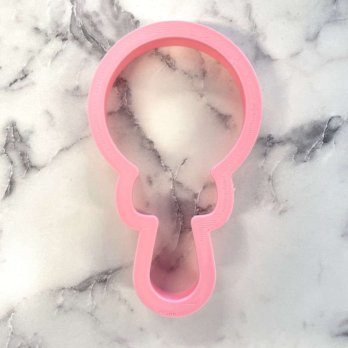 Pink plastic lollipop key-shaped cookie cutter for baking and crafting fun shaped treats